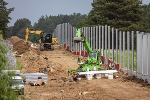 عمال يقومون ببناء جدار حدودي على طول الحدود البولندية البيلاروسية بالقرب من المعبر الحدودي المغلق في كوزنيكا، مقاطعة سوكولكا، محافظة بودلاسكي، في شمال شرق بولندا في 8 يونيو 2022 - سبوتنيك عربي