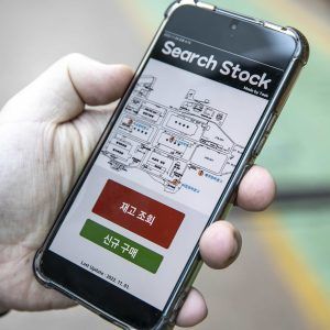 A person holding a phone depicting the Search Stock app