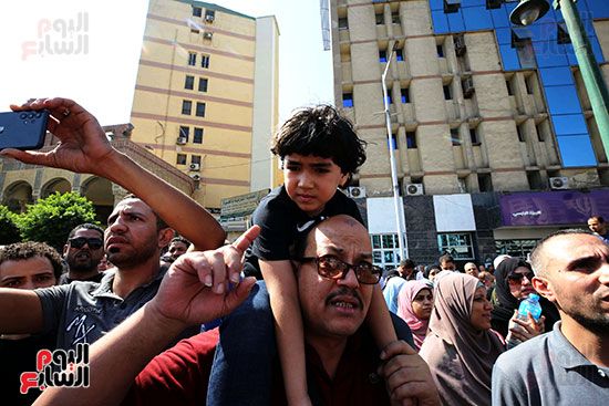 أب يحمل ابنه بمظاهرة ميدان الجيزة