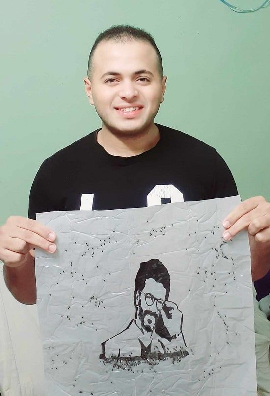 محمد يحمل لوحة للفنان خالد النبوى