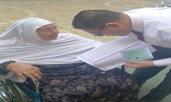 قاضٍ يساعد سيدة مسنّة على الإدلاء بصوتها داخل لجنة بإيتاي البارود