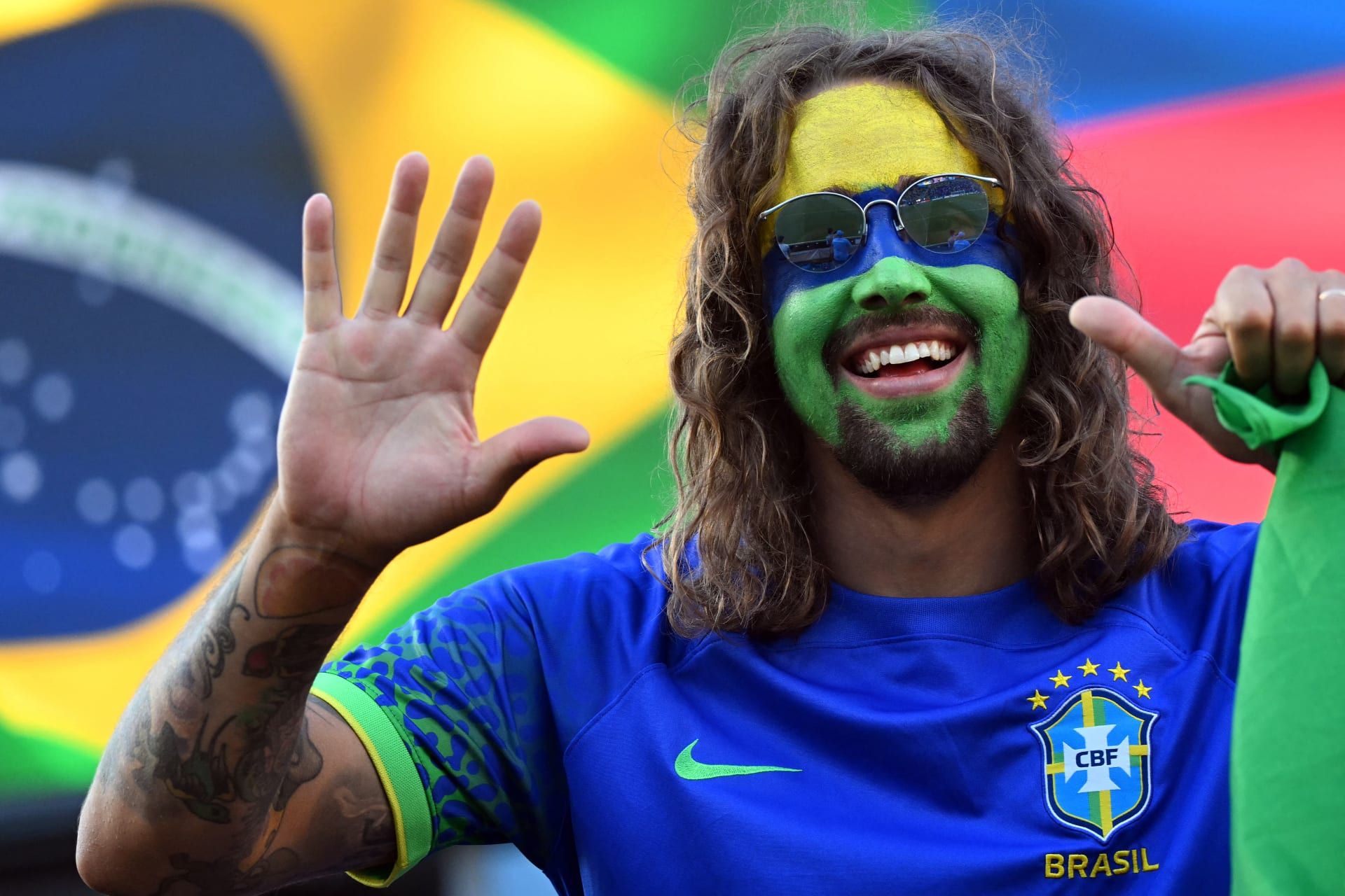 ألوان العلم البرازيلي على وجوه مشجّعي المنتخب.
